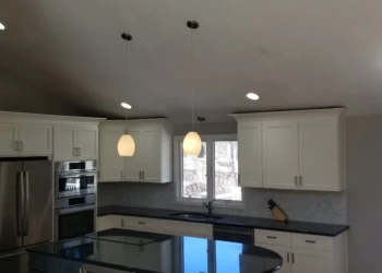 Kitchen cabinets being refinished in a modern kitchen.