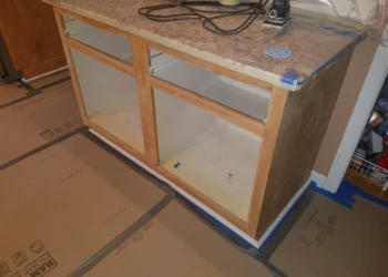 Wood kitchen base cabinets with removed doors and drawers ready for refinishing in Pelham NH