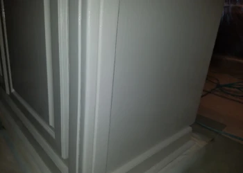 Close-up of gray kitchen cabinet corners with smooth finish during cabinet refinishing in Pelham, New Hampshire
