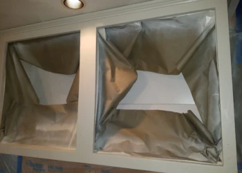 Upper kitchen cabinets masked and prepped for cabinet refinishing in Pelham, NH
