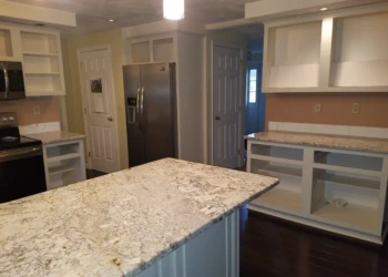Kitchen with newly refinished white cabinets and beige granite countertops, stainless steel appliances in Pelham NH