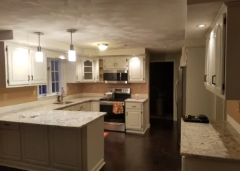 Pelham kitchen with white refinished cabinets, granite counters, stainless appliances, and dark wood flooring