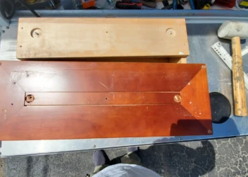 Wooden kitchen cabinet door with repaired and stripped finish on workbench with tools in Windham, NH