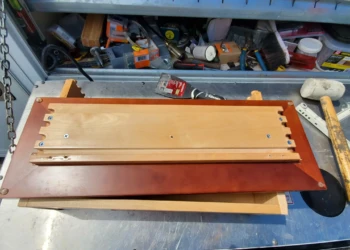 Disassembled kitchen cabinet drawer piece with visible wood repairs and workbench tools in Windham, NH workshop