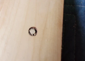 Close-up of wooden cabinet drawer with repaired drilled hole during cabinet painting in Windham NH