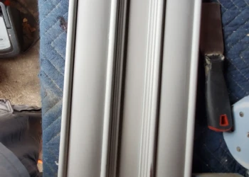 Single kitchen cabinet door panel with detailed molding placed on blue padded surface during cabinet painting in Windham NH