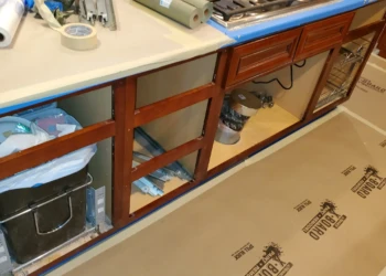 Wooden kitchen cabinet frames with drawers and hardware removed for painting and repairs in Windham, NH kitchen