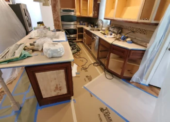 Kitchen with stripped and partially repaired cabinets during cabinet painting in Windham, NH