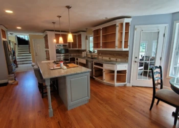 Kitchen with white cabinets and gray island cabinets without doors, showing cabinet painting in Windham, NH preparations